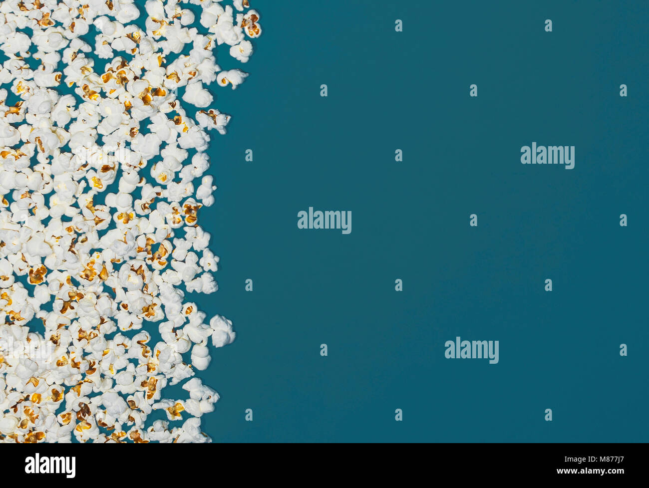 Popcorn isoliert auf blauem Hintergrund, Mikrowelle Nahrung Stockfoto
