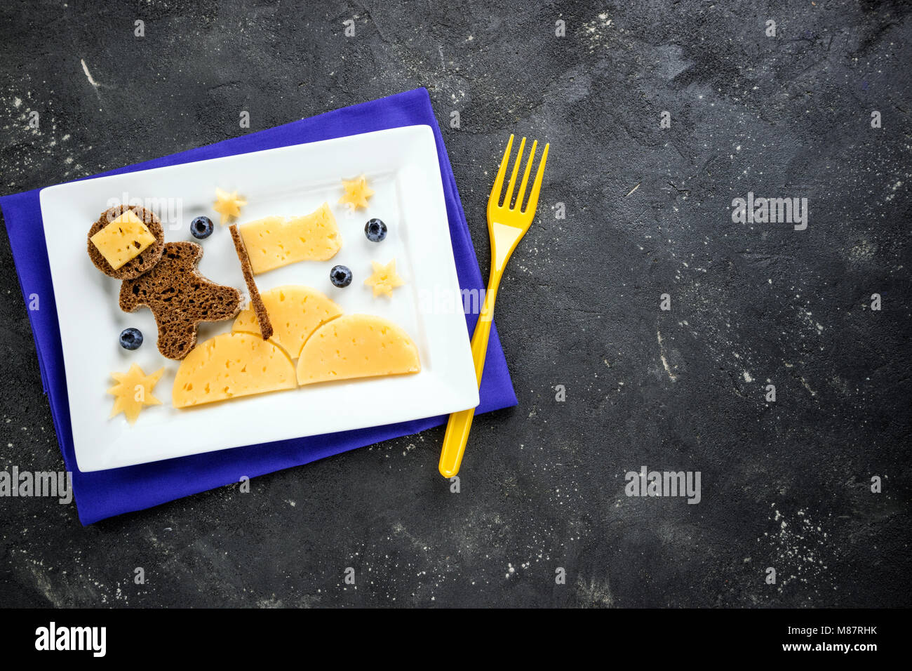 Kinder Frühstück mit kreativen Sandwich auf dunklen Raum Hintergrund top anzeigen, kopieren. Lustige Toast mit Käse und Beeren in der Form Astronaut für Ch Stockfoto