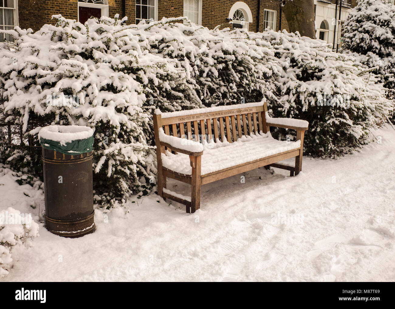 Öffentliche Abfallbehälter und Parkbank viktorianischen Häusern, hinter London Winter mit Schnee bedeckt Stockfoto