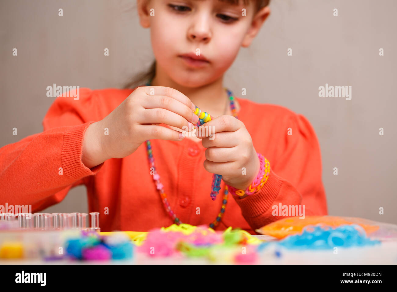 Hobby nette Mädchen Webart hellen farbigen rubber Bracelets an Arbeit fokussiert Stockfoto