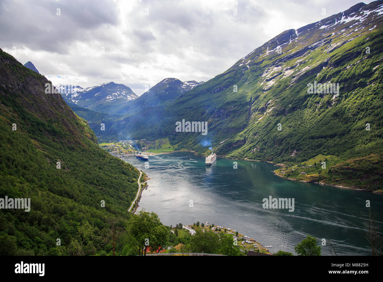 Blick auf den Geirangerfjord mit Kreuzfahrtschiffen und das Dorf Geiranger am Ende des Fjords Stockfoto