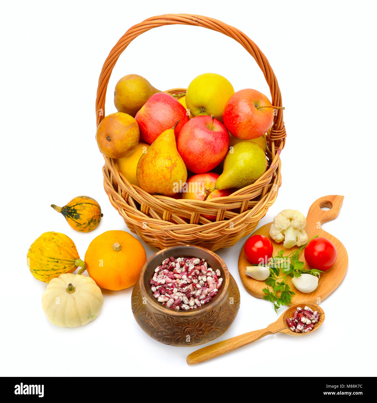 Früchte, die in einem Korb auf weißem Hintergrund Stockfoto