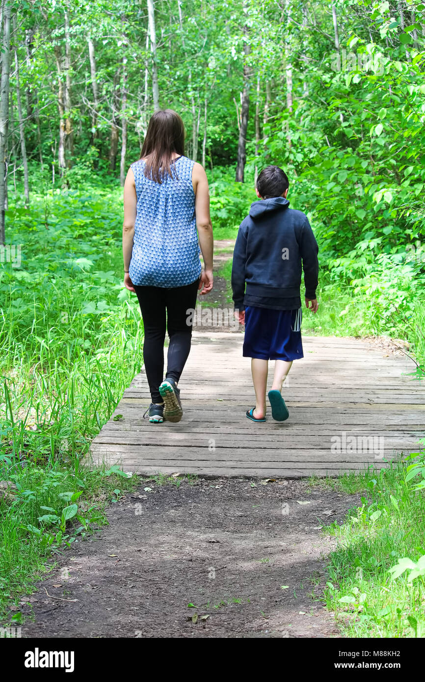 Ein junges Mädchen und Jungen einen Spaziergang in den Wald nehmen Stockfoto