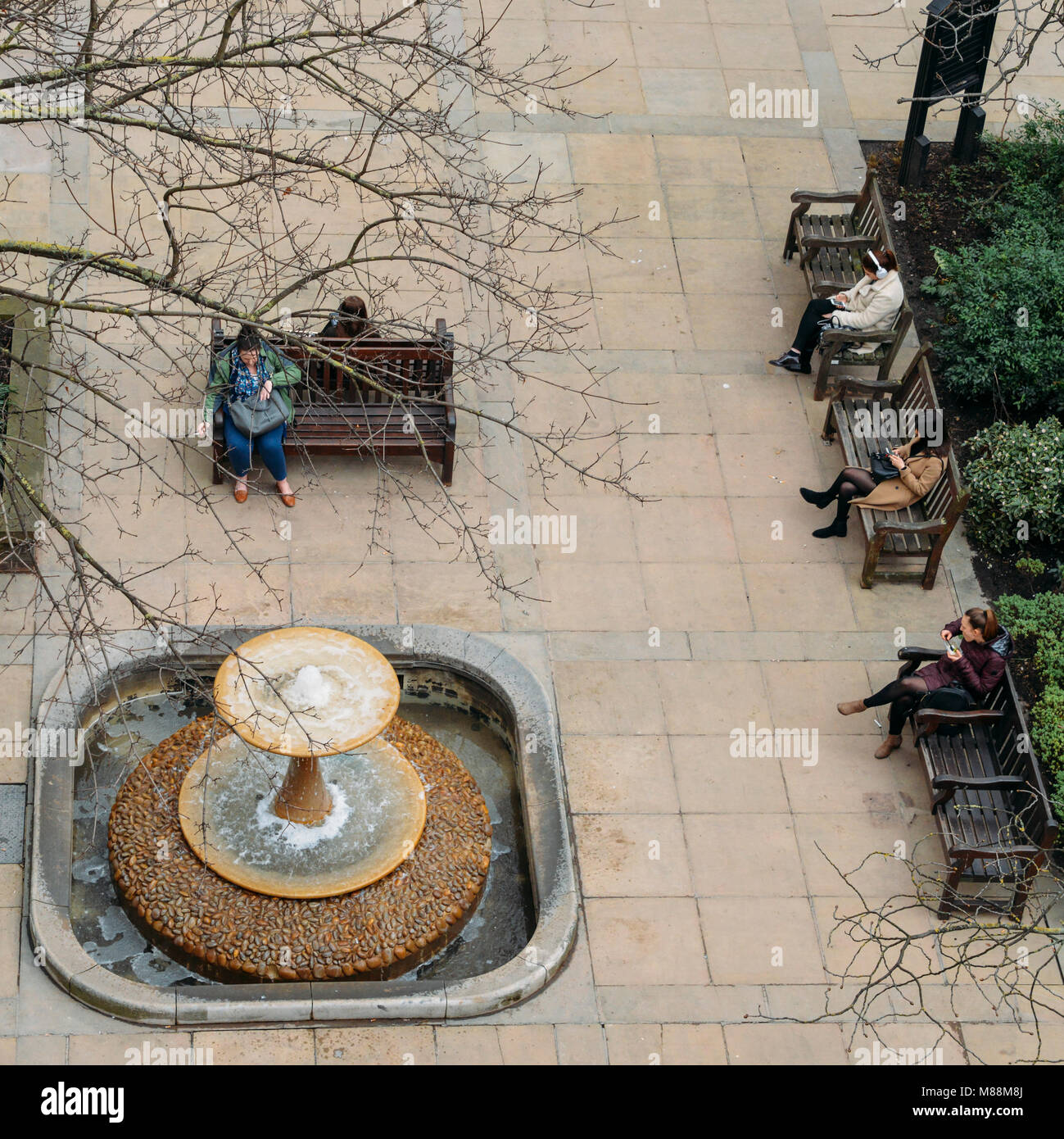 London, Großbritannien, 13. März 2018: Blick von der Londoner City Arbeitnehmer bei Whittington Gärten neben einem Springbrunnen entspannen Stockfoto