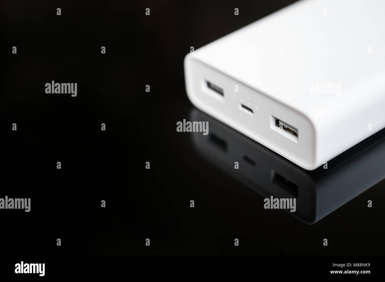 White Power Bank auf verspiegelte Oberfläche. Platz für Ihren Text. Stockfoto