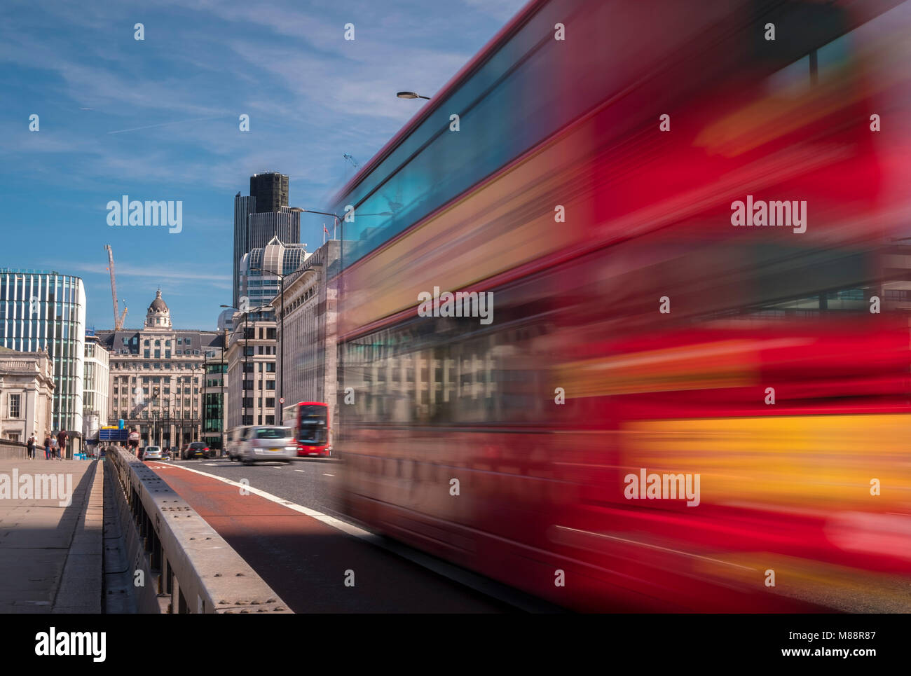 Bewegung eines London Bus Geschwindigkeiten über London Bridge in Richtung auf die Stadt, die auf einem Morgen Sommer Stockfoto