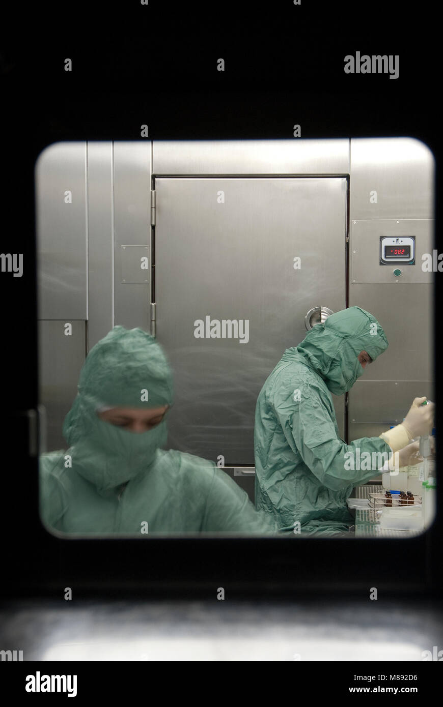 Manipulationen mit Schutzanzügen im Labor Stockfoto