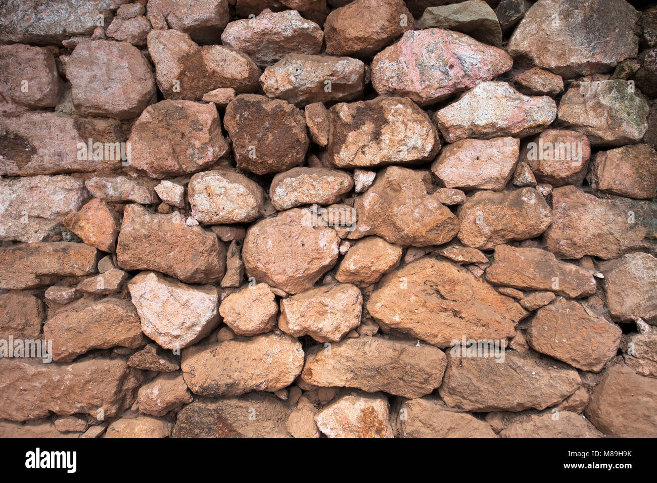 Steinmauer ist handgemacht, die Felsbrocken sind gerundete Form verschiedener Größe, übereinander gestapelt. Stockfoto