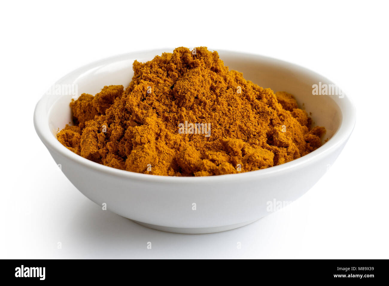 Curry Pulver in weißer Keramik Schüssel isoliert auf Weiss. Stockfoto
