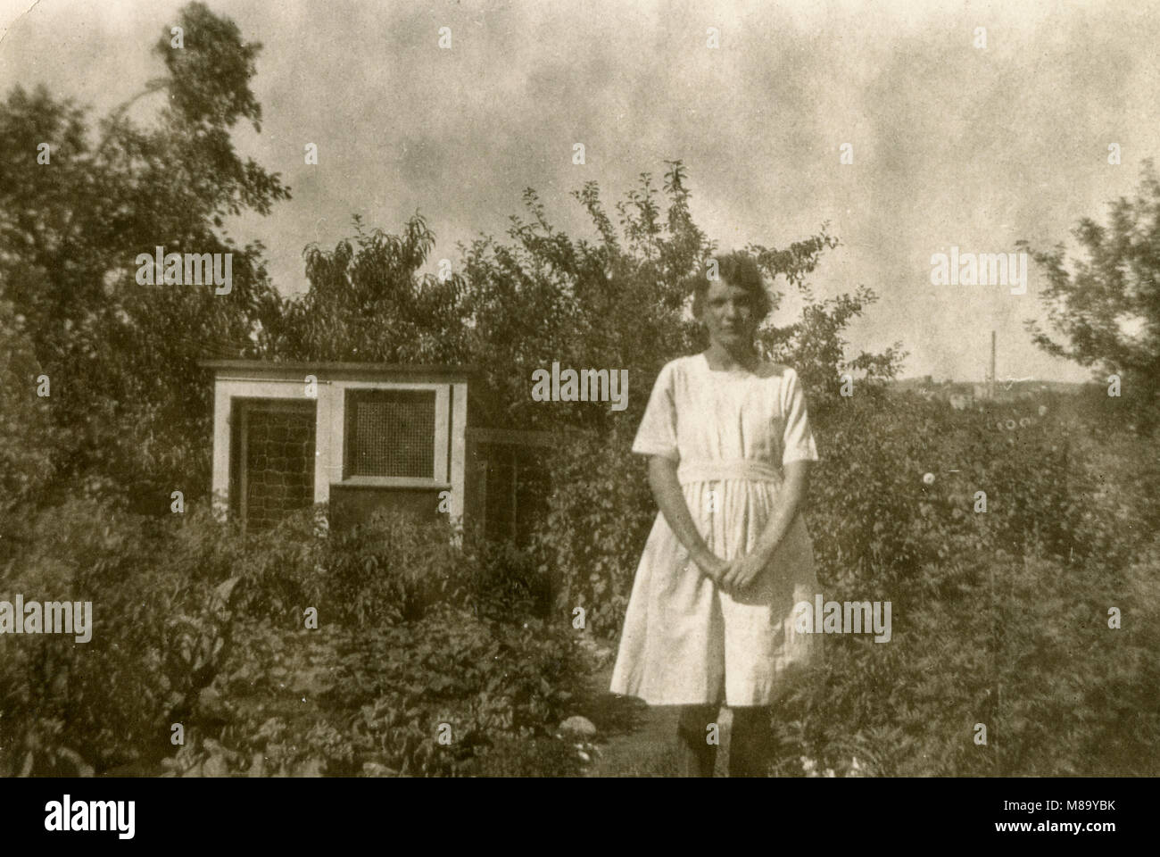 Antike c 1920 Foto, junge Frau in der Nähe des Gartens und Kaninchenstall. Quelle: original Foto. Stockfoto