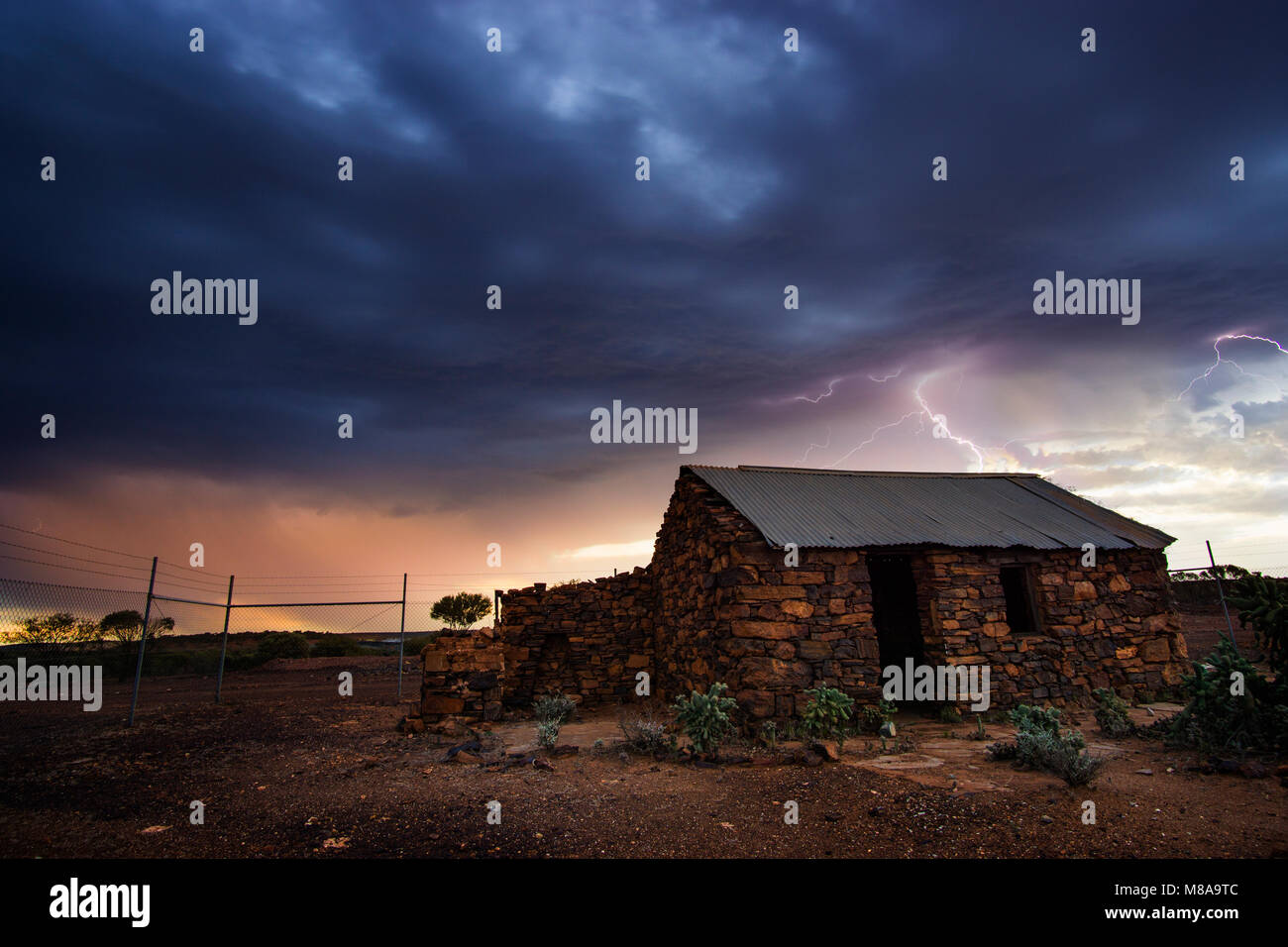 Sturm nähert sich abgebrochene Stein Bergleute cottage bei Sonnenuntergang, Mt Magnet Goldfields, Western Australia Stockfoto