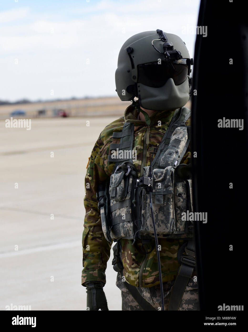 Ein U.S. Army Crew Chief mit dem 1-135 th Assault Helicopter Bataillon überwacht ein UH-60 Black Hawk, bevor Sie sich bei einer gemeinsamen Ausbildung bei Whiteman Air Force Base, Mo, 31.01.2018. Neben der Gründung einer Partnerschaft, das Ziel des Trainings war es, gemeinsame Klemme Attack Regler aus dem 7. Air Support Operations Squadron in Fort Bliss, Texas entfernt vertraut zu machen, mit den Aktiven am Whiteman AFB zur Verfügung, die in einem Multi-domain kämpfen. (U.S. Air Force von Staff Sgt. Danielle Quilla) Stockfoto