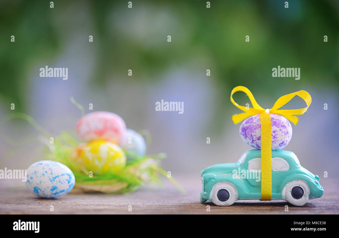 Spielzeugauto mit Osterei im Frühling Stockfoto