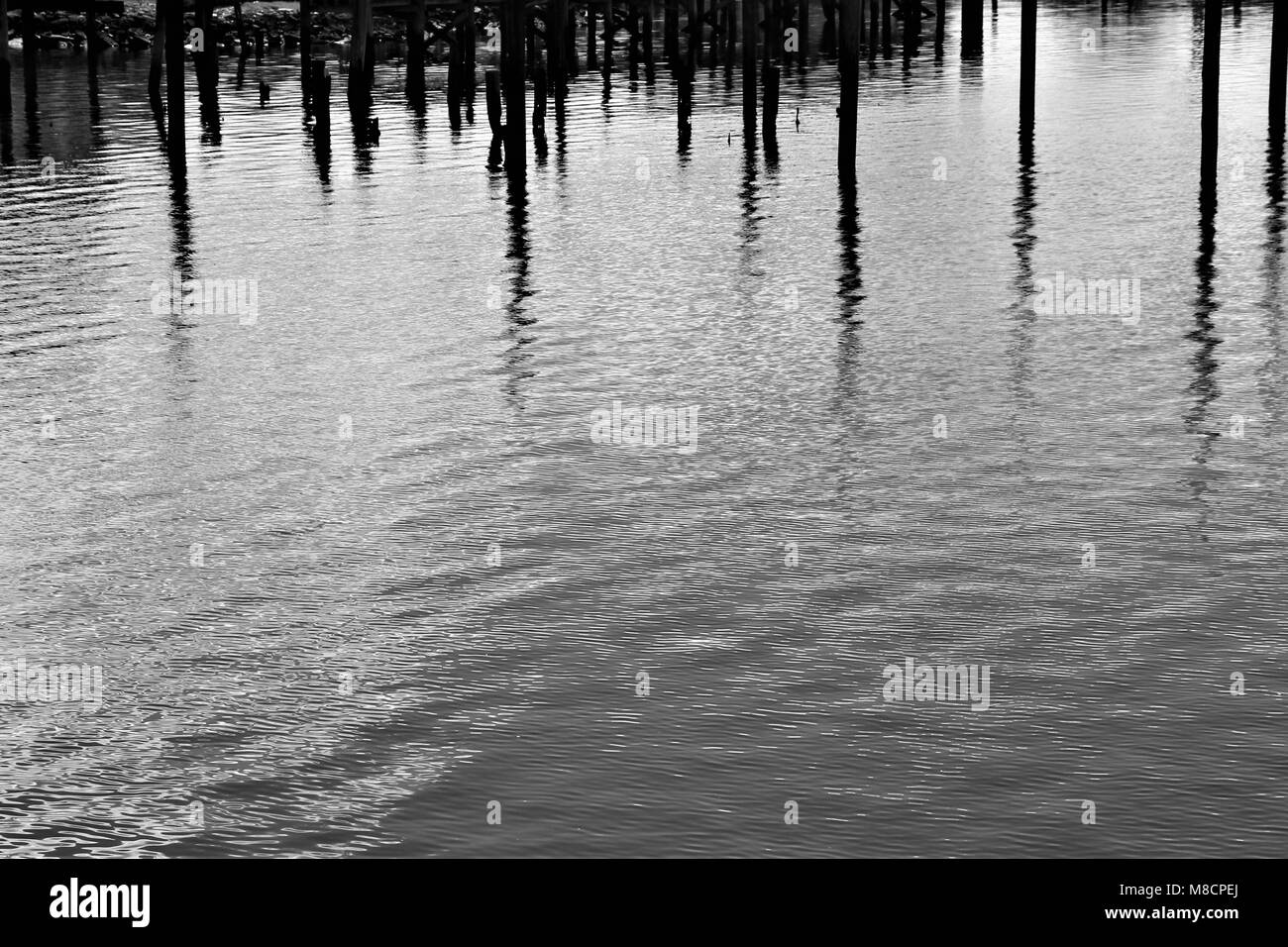 Plätschern des Wassers mit reflektiertem Piers. Stockfoto