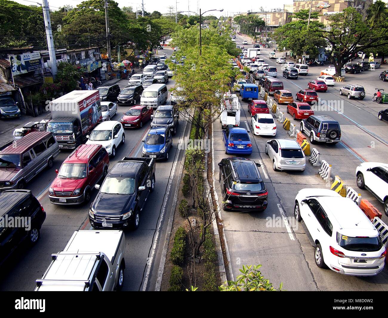 QUEZON CITY, Philippinen - 9. MÄRZ 2018: Fahrzeuge Pass entlang einer in der Regel stark befahren Katipunan Avenue in Quezon City, Philippinen. Stockfoto