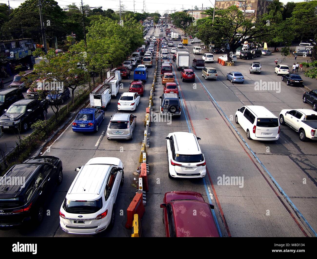 QUEZON CITY, Philippinen - 9. MÄRZ 2018: Fahrzeuge Pass entlang einer in der Regel stark befahren Katipunan Avenue in Quezon City, Philippinen. Stockfoto