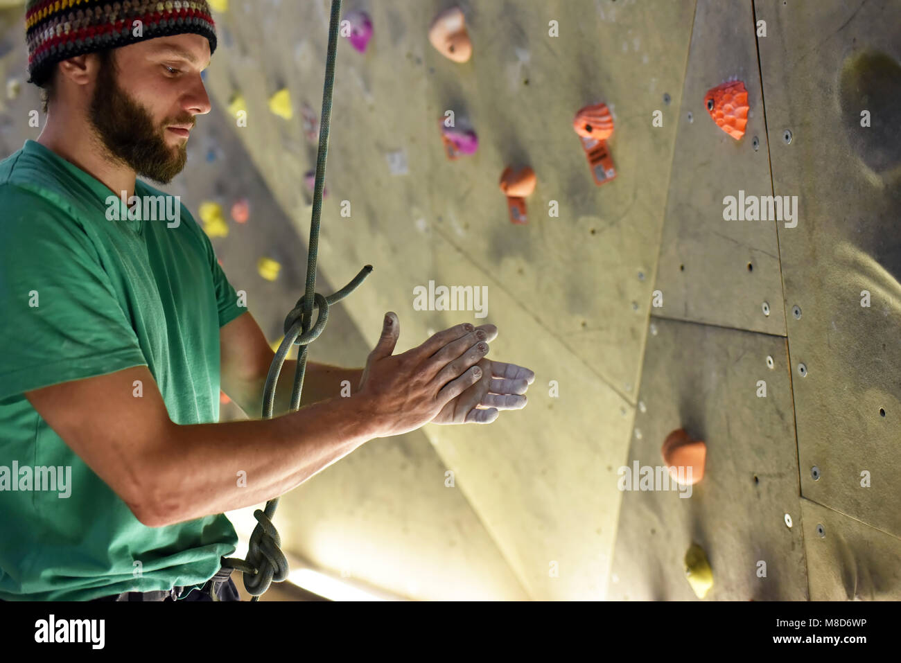 Sportler in einem Boulder Halle reibt sich die Hände mit Kreide, Vorbereitung klettern Sport Stockfoto