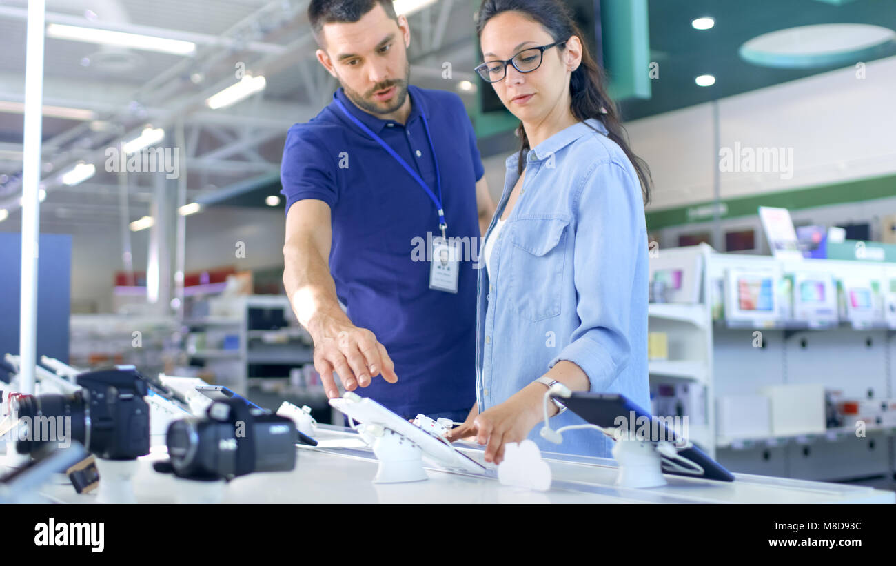 In der Unterhaltungselektronik Berater bietet professionelle Beratung, eine junge Frau, Sie hält den Kauf neuer Tablet-PC und Gutachten. Stockfoto