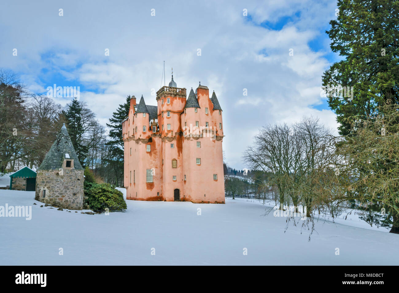 CRAIGIEVAR CASTLE ABERDEENSHIRE SCHOTTLAND MIT DEM rosa Turm, UMGEBEN VON SCHNEE IM WINTER UND IMMERGRÜNE PINIEN Stockfoto