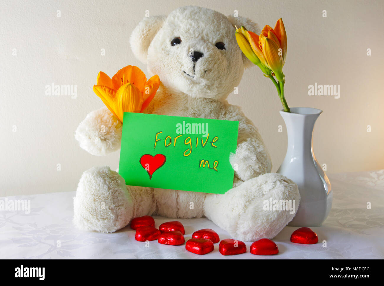 Süße Weißer Teddybär Holding agreen Zeichen, das sagt mir vergeben Stockfoto