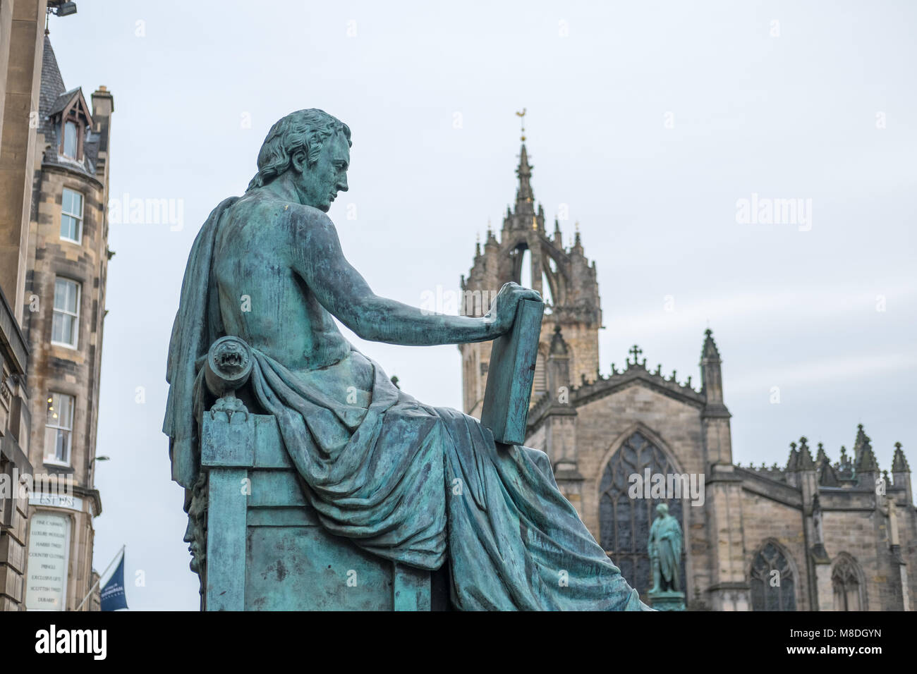 David Hume Statue mit St. Giles Kathedrale auf dem Hintergrund auf der Royal Mile in Edinburgh, Schottland Stockfoto