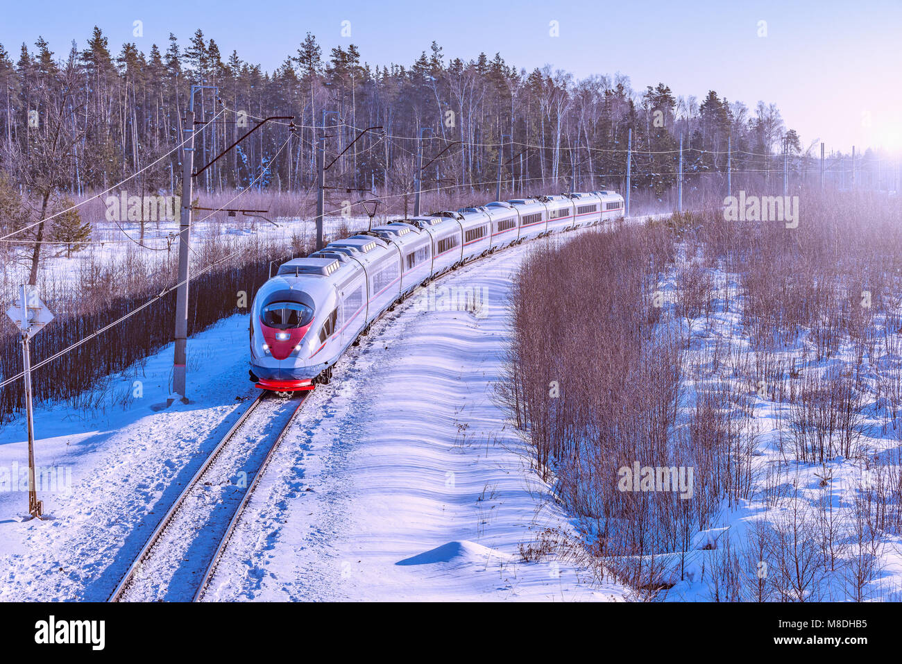 Moderne Hochgeschwindigkeitszug bewegt sich schnell im Winter morgen Zeit. Stockfoto
