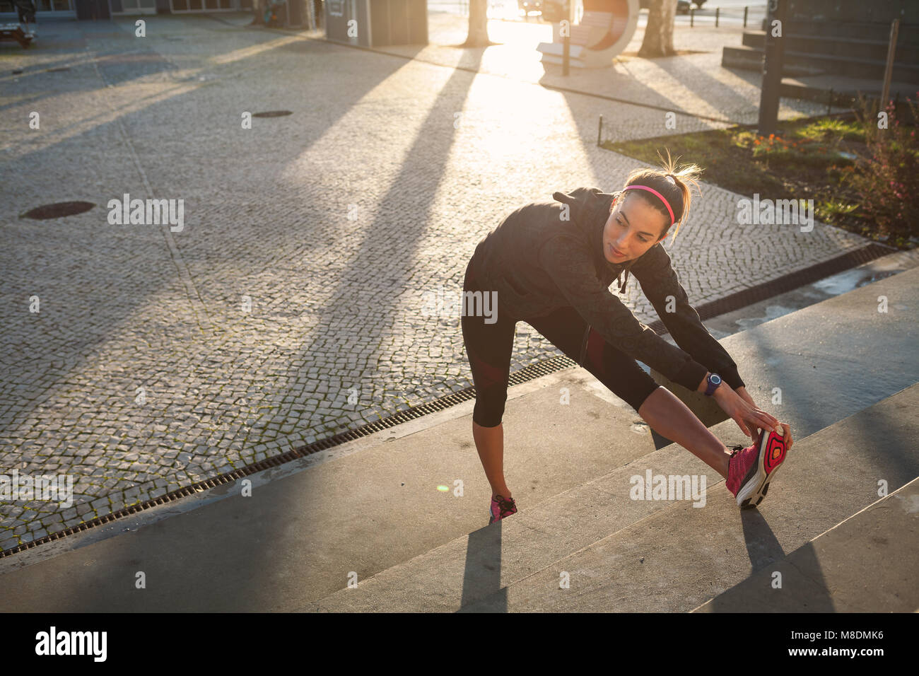 Junge Frau aufwärmen, Stretching Beine Stockfoto