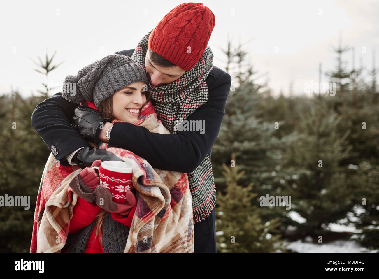 Romantische junge Paar in christmas tree forest in Decke gewickelt Stockfoto