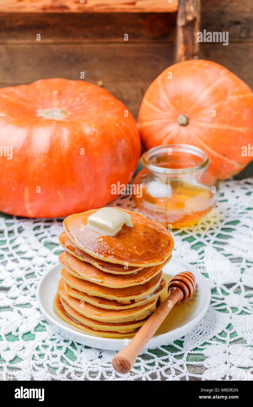 Hausgemachte Kürbis Pfannkuchen mit Butter und Honig auf einem weißen Teller auf dem Tisch. Nützliches, leckeres Frühstück. Selektiver Fokus Stockfoto