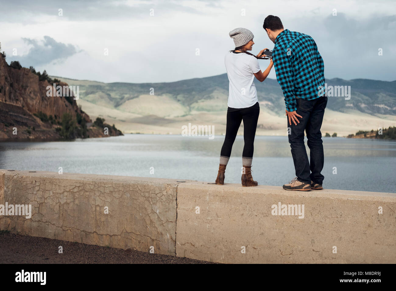 Paar stehend auf Wand neben Dillon Reservoir, an der Kamera suchen, Ansicht von hinten, Silverthorne, Colorado, USA Stockfoto