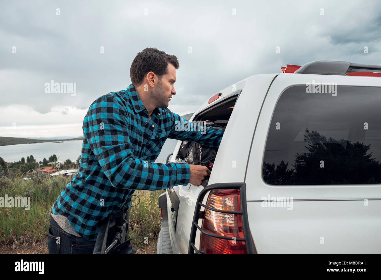 Mitte der erwachsene Mann ins Fenster der geparkten Auto, Silverthorne, Colorado, USA Stockfoto