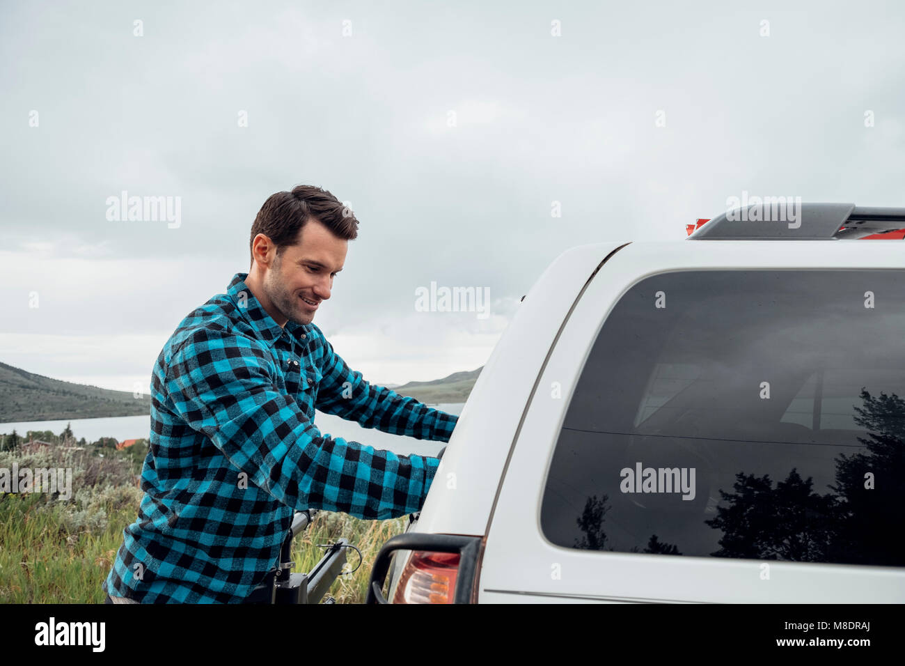 Mitte der erwachsene Mann stand neben der geparkten Auto, Silverthorne, Colorado, USA Stockfoto