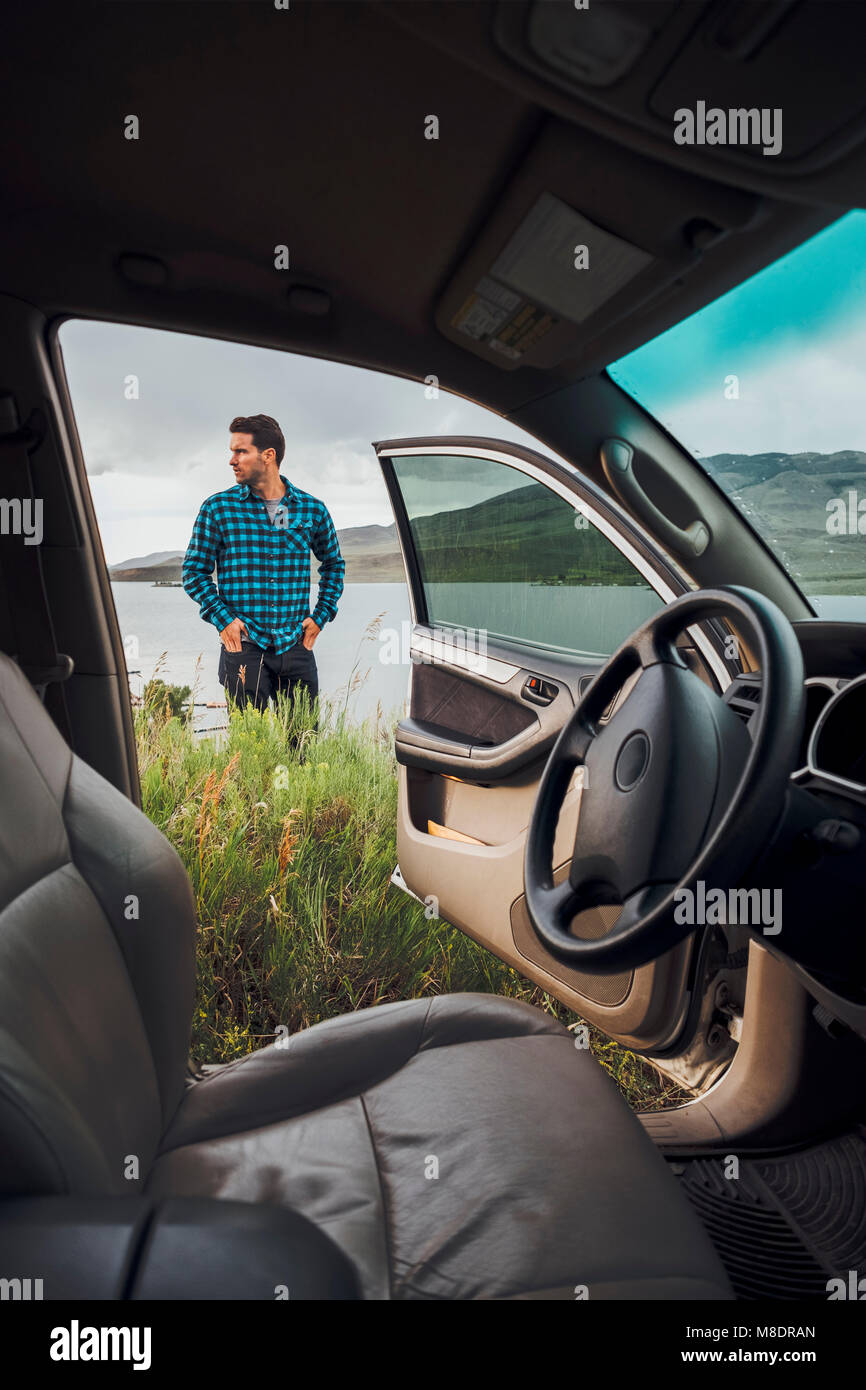 Mitte der erwachsene Mann stand neben Dillon Reservoir, Blick durch die geparkten Auto, Silverthorne, Colorado, USA Stockfoto