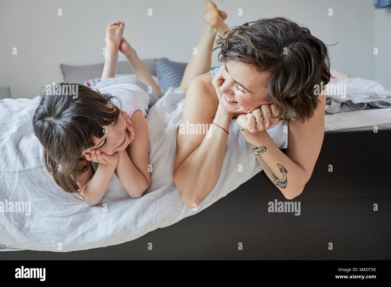 Mutter und Tochter auf Bett, Lächeln Stockfoto