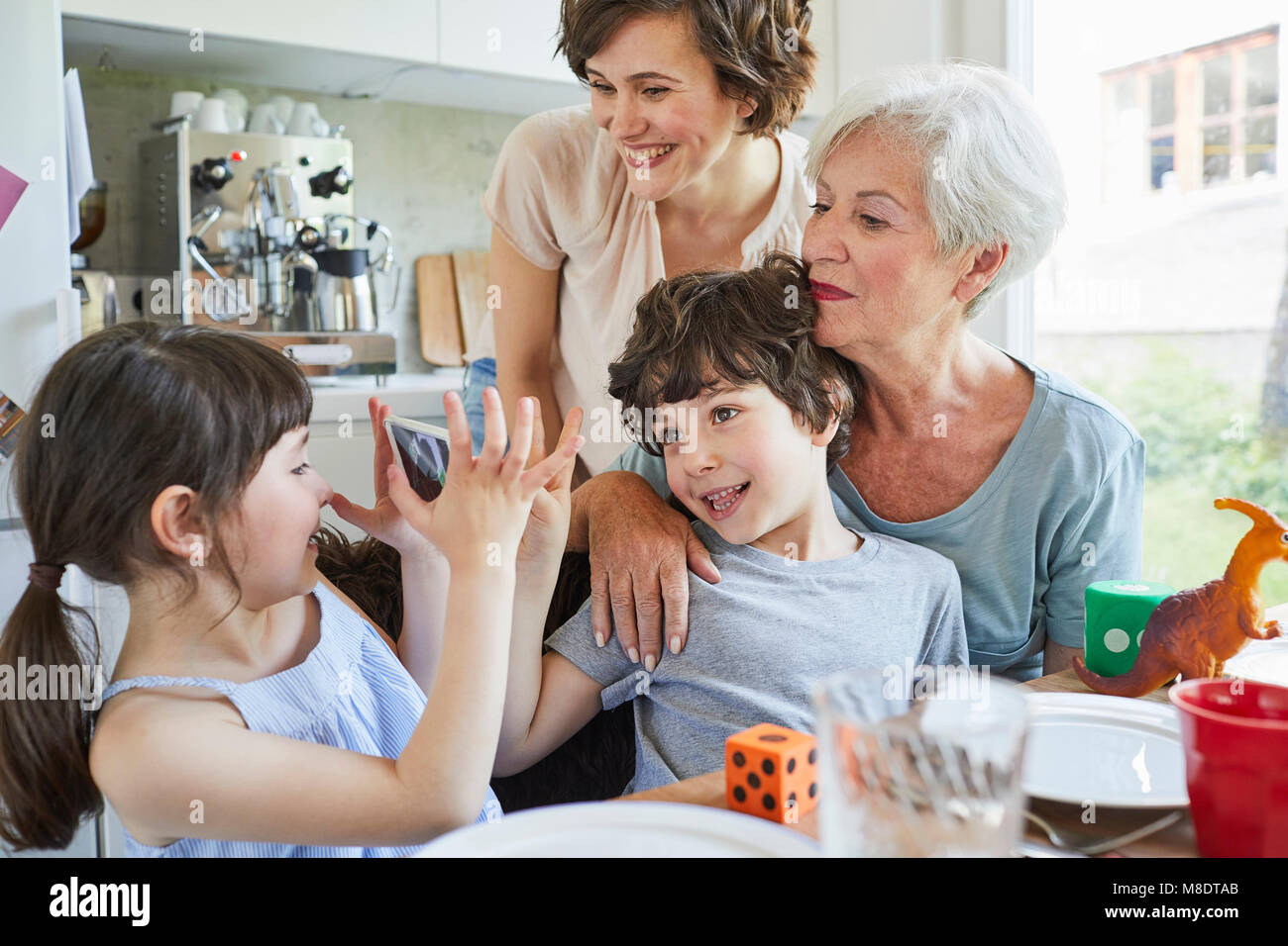 Junge Mädchen fotografieren, Bruder, Mutter und Großmutter, mit Smartphone Stockfoto