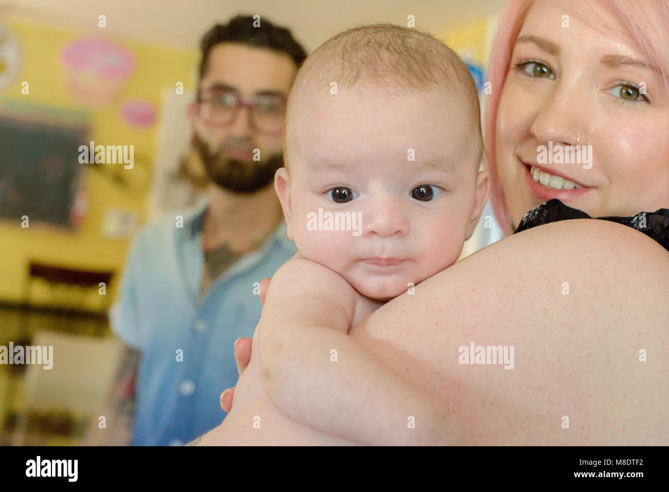 Frau mit baby boy, Mann im Hintergrund Stockfoto