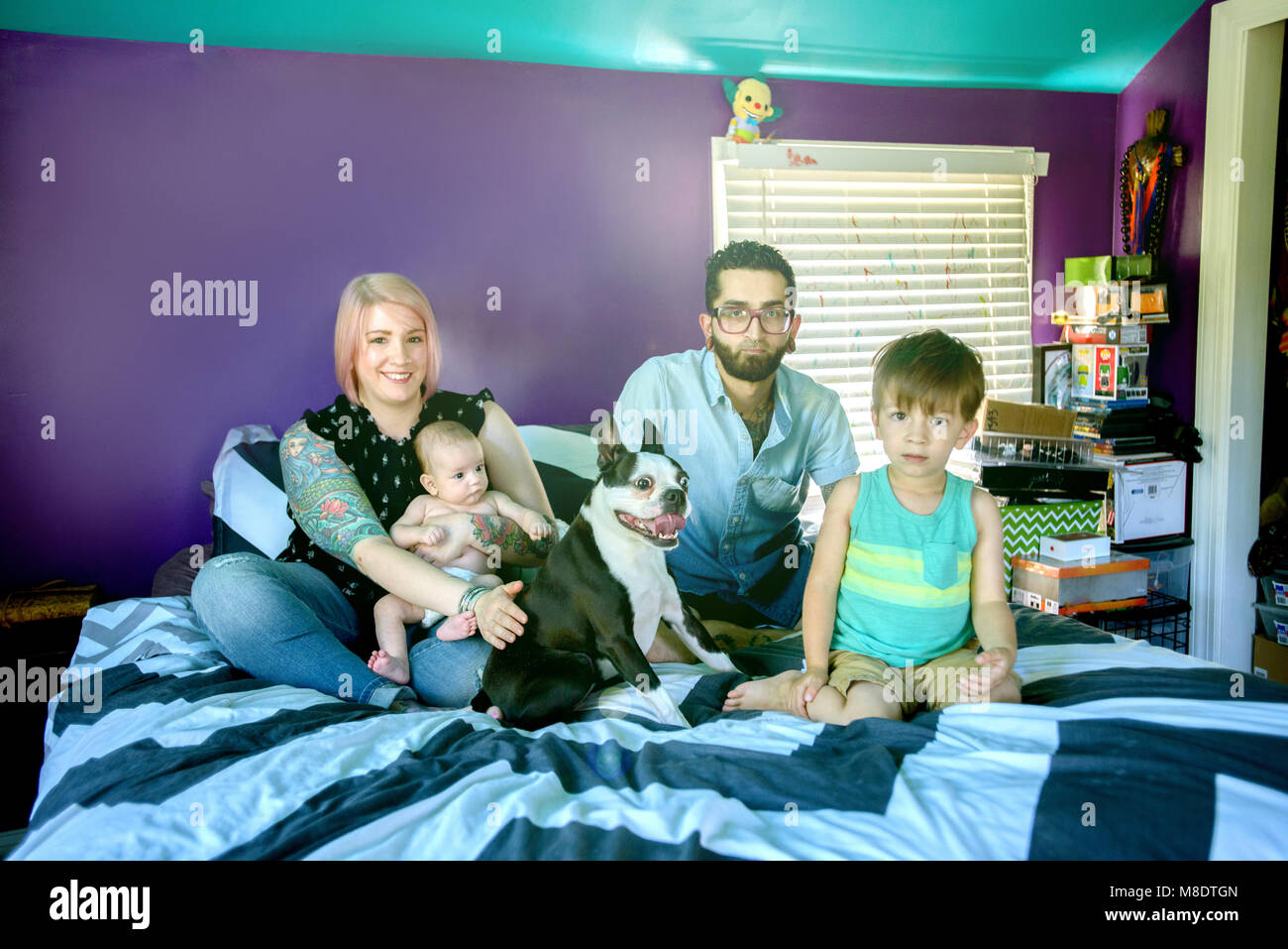 Familie auf dem Bett im Schlafzimmer Stockfoto