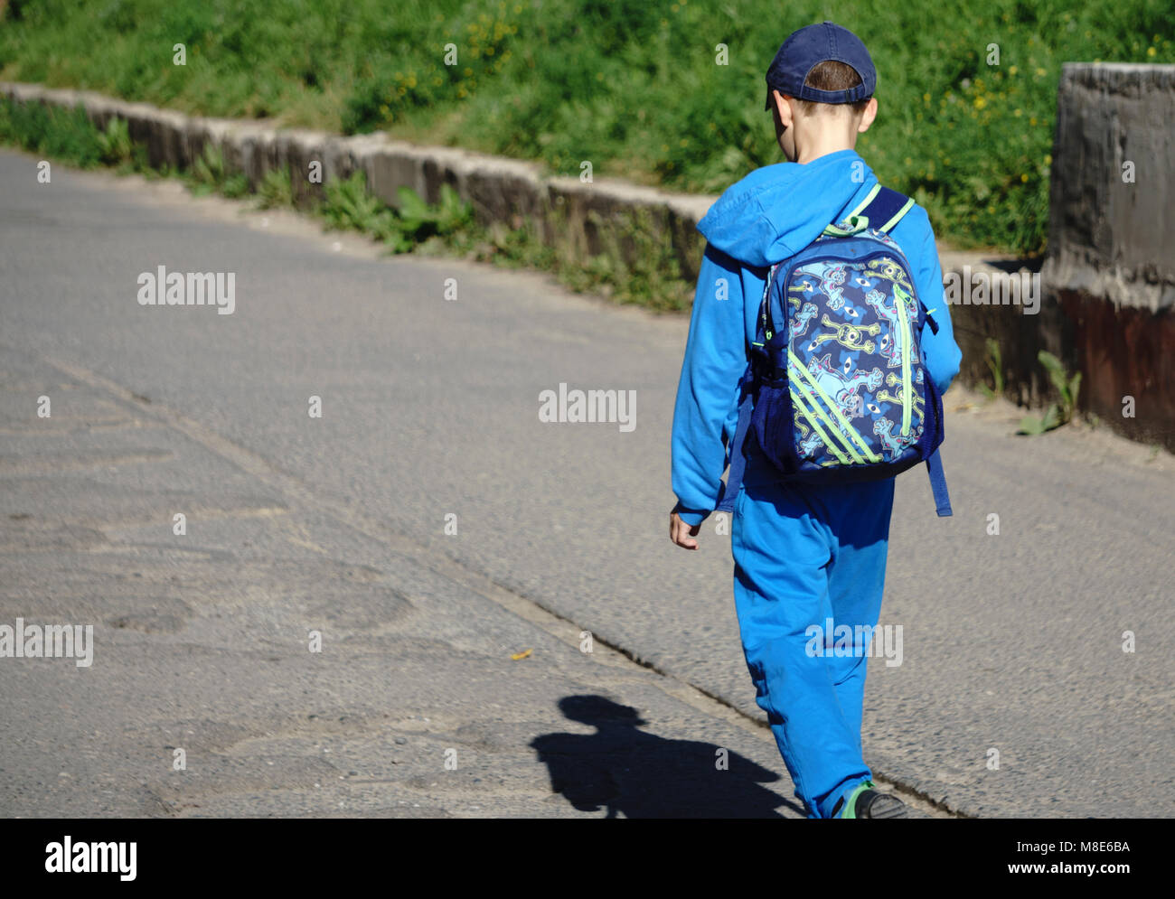 Junge kommt von der Schule nach Hause mit Rucksack Stockfoto