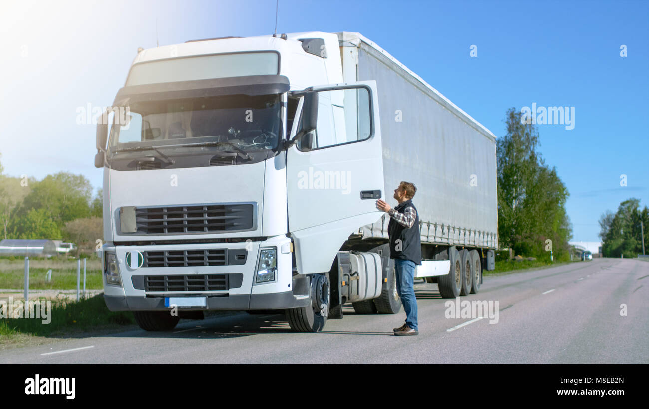 Lkw-Fahrer aus seinem geparkten Weißen Lkw Cab-Over. Tag ist sonnig ...