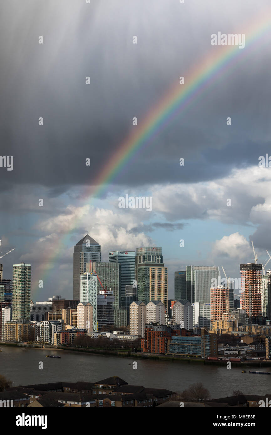 London, Großbritannien. 16. März, 2018. UK Wetter: Ein Regenbogen bricht über Canary Wharf business park Gebäude in East London während einem Nachmittag Regensturm. © Guy Corbishley/Alamy leben Nachrichten Stockfoto