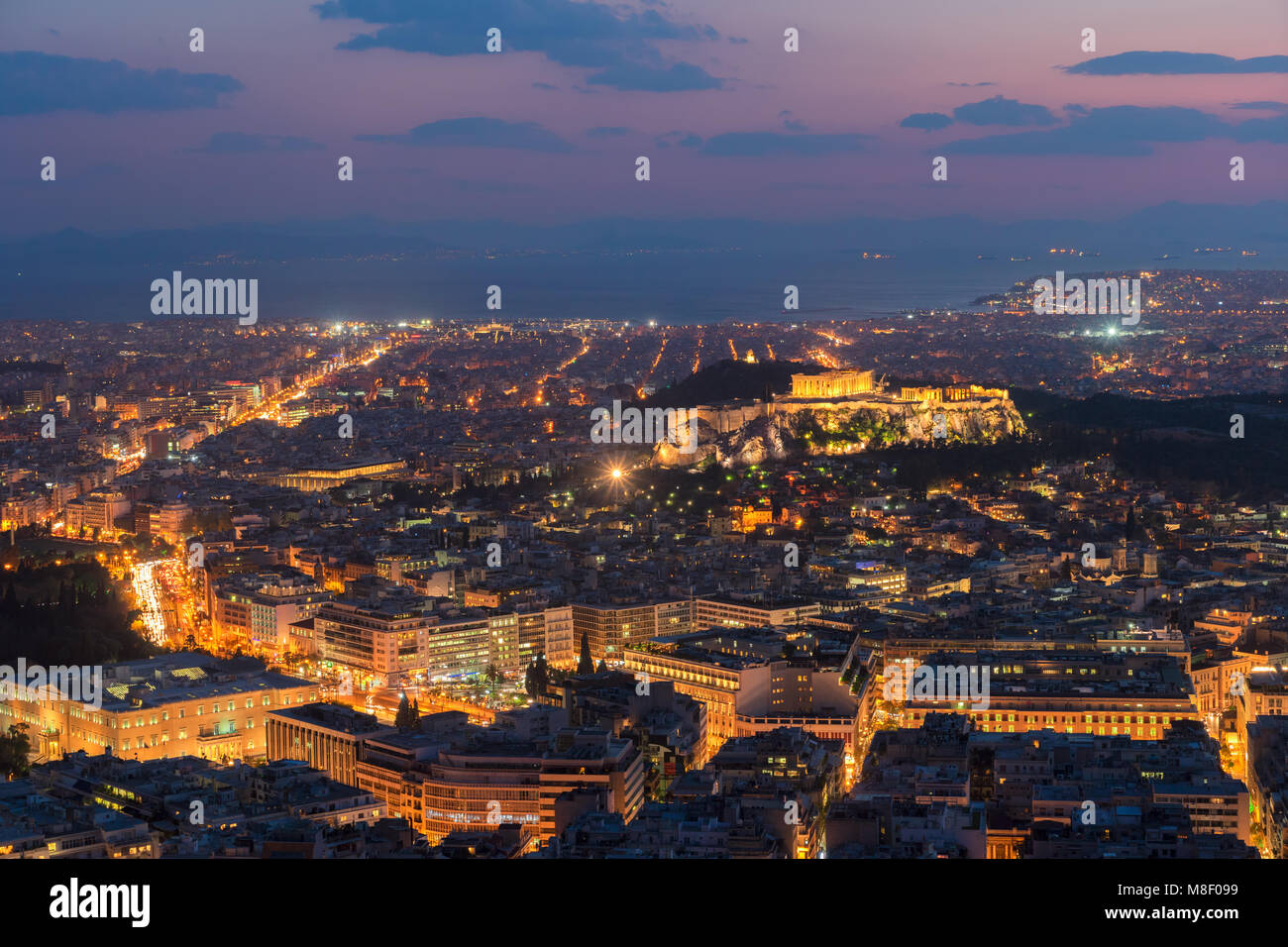 Panorama Stadtbild von Athen mit Acorpolis Hügel und das Meer in der Nacht, Griechenland Stockfoto