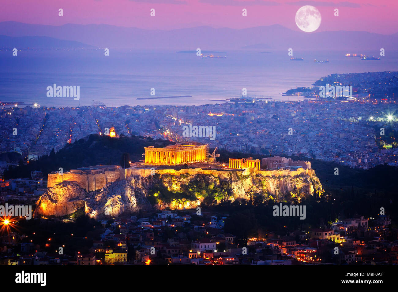 Stadtbild von Athen mit beleuchteten Akropolis Hügel und sehen, Pathenon und Meer in der Nacht, Griechenland Stockfoto
