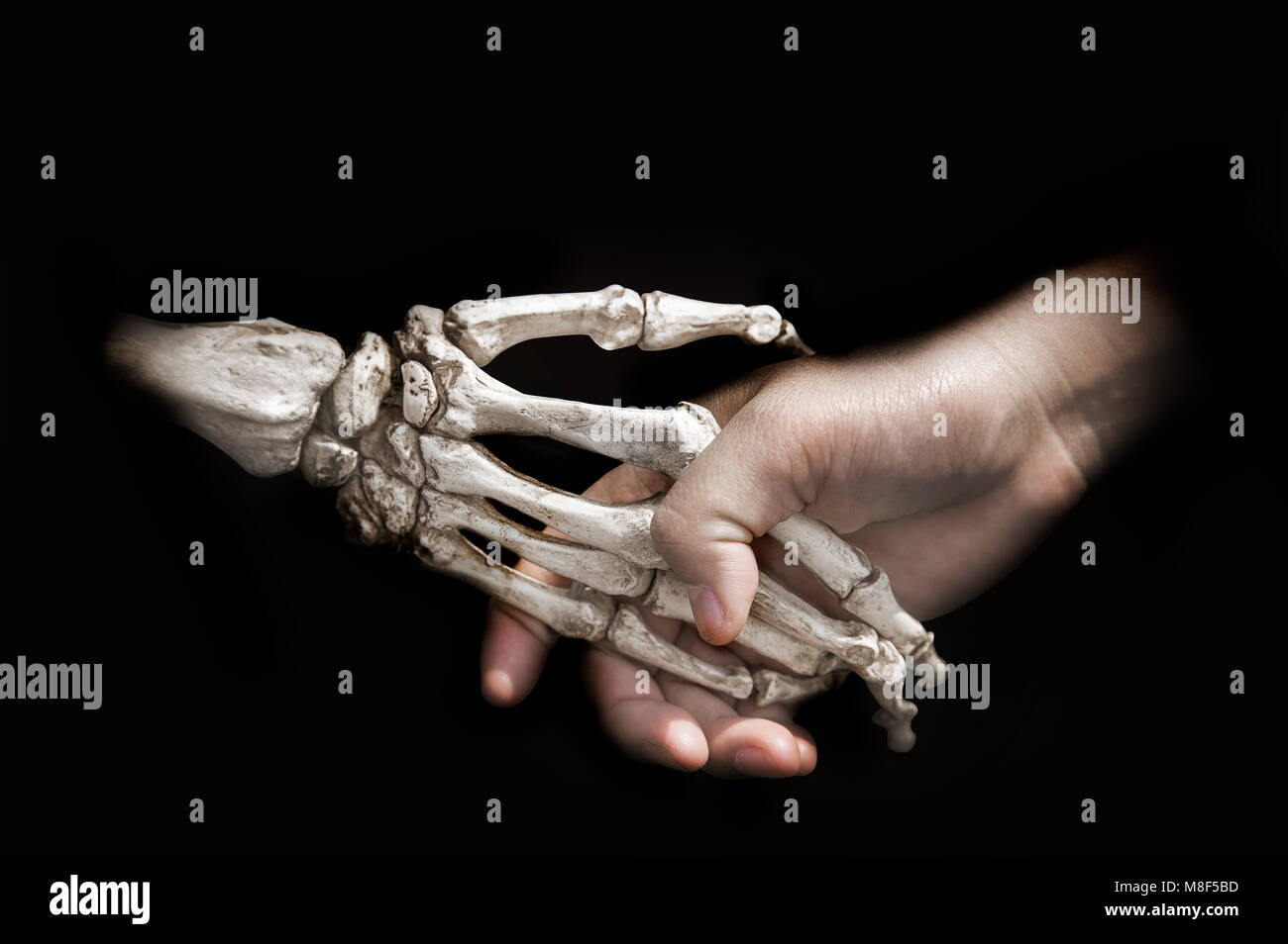 Die Hand schütteln mit dem Tod Knochen auf Schwarz zeigen Vereinbarung Vertrag mit Mensch und Geist Stockfoto