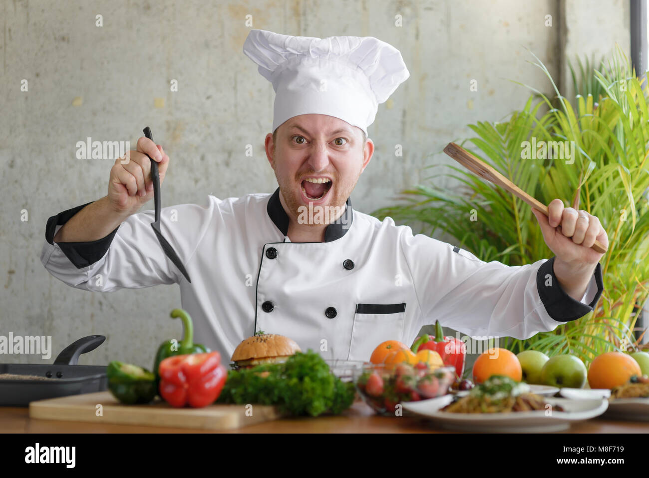 Betont professionellen Koch Holding Spachtel mit Gemüse auf den Tisch. Stockfoto