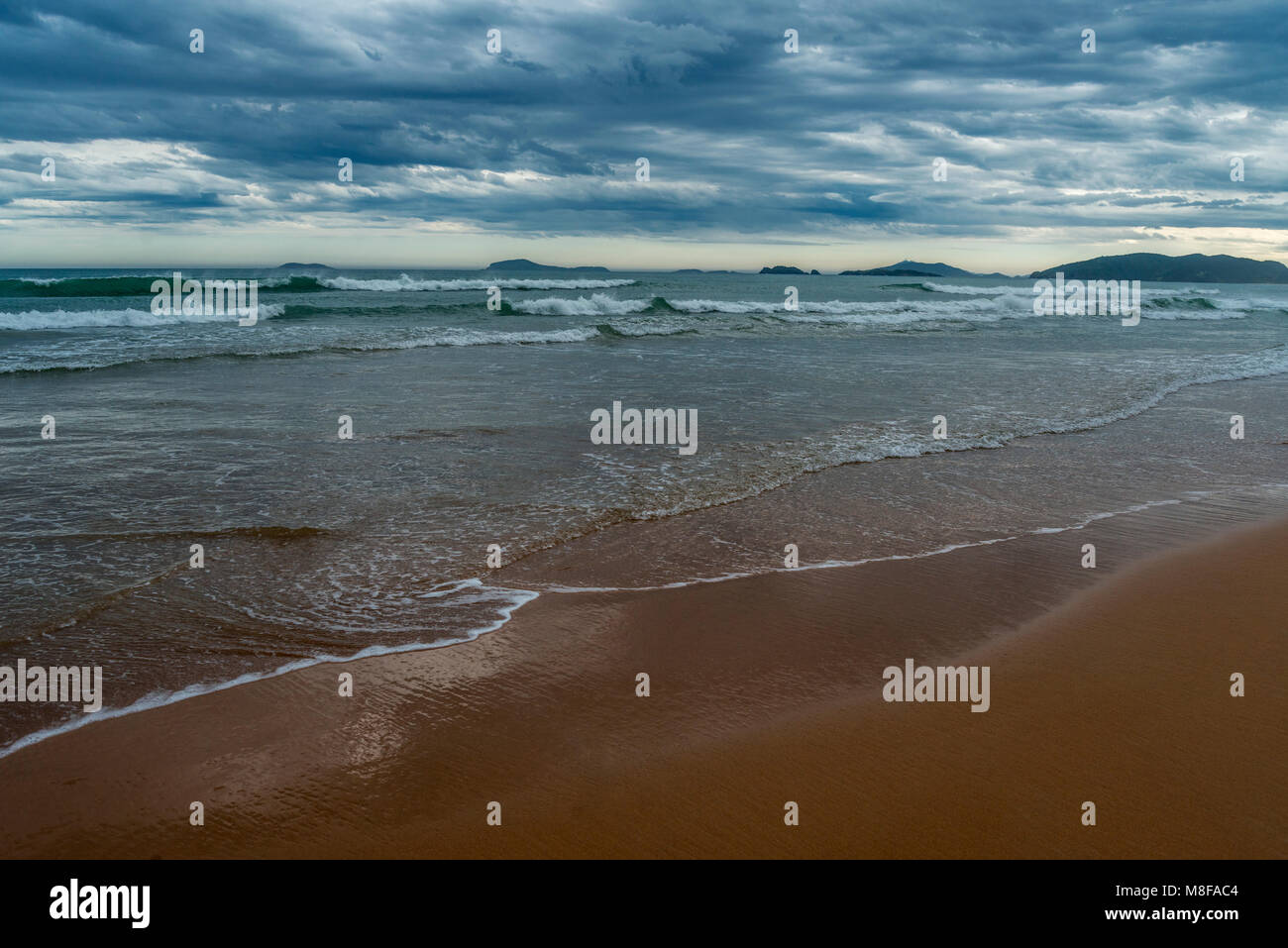 Sonnenuntergang am Strand mit bewölktem Himmel der dramatische Aspekt Stockfoto