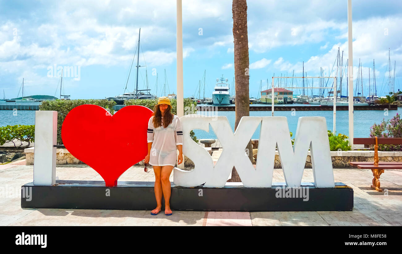 Die Frau posiert in der Nähe von Zeichen und Statue I St Martin in Marigot, St. Maarten Liebe. Stockfoto