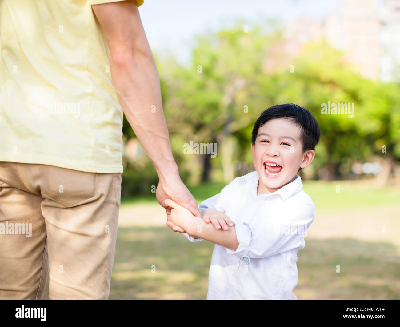 Vater hält die Hand des kleinen Jungen Stockfoto