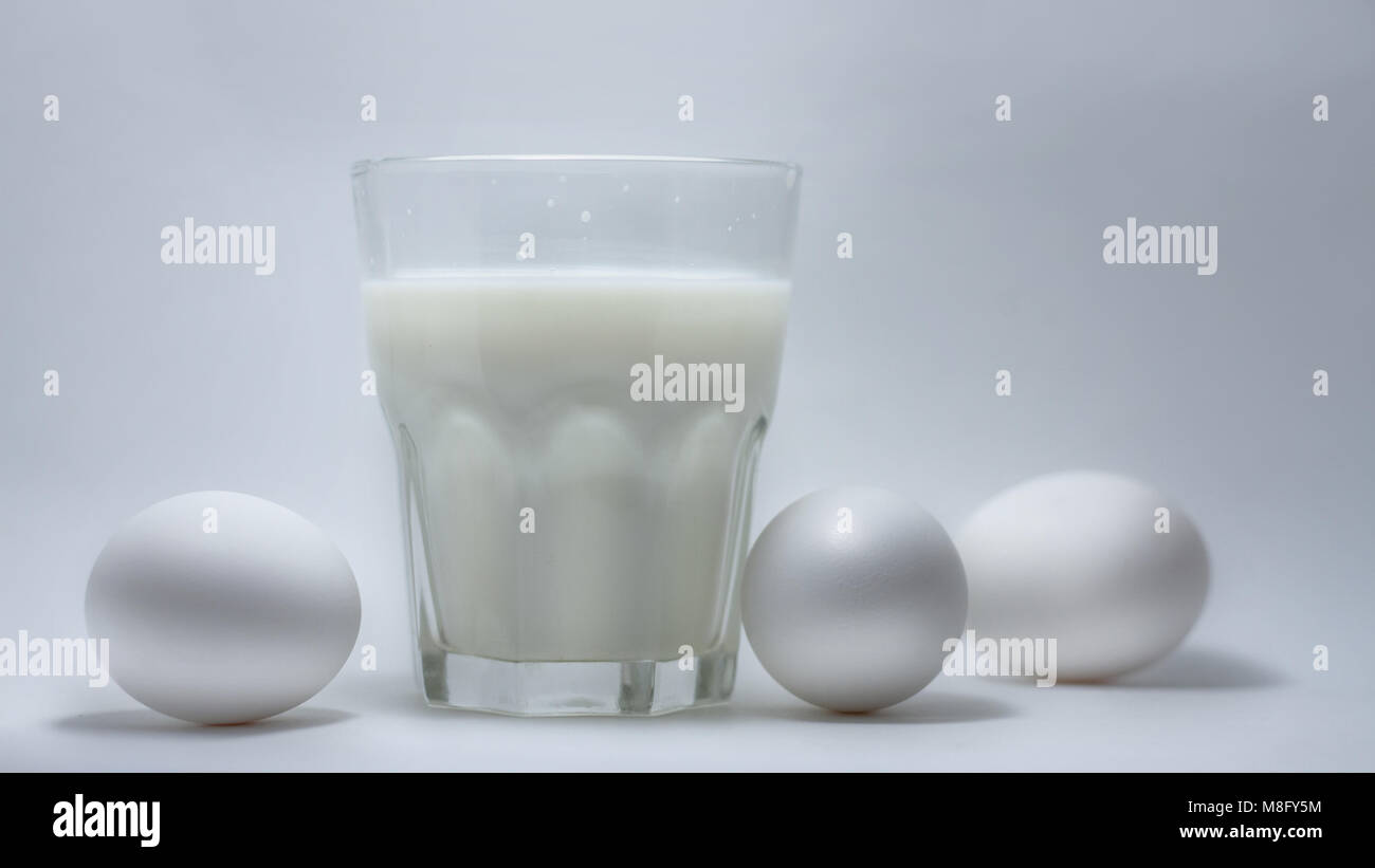 Ein Glas Milch auf einem weißen Hintergrund Eier Stockfoto