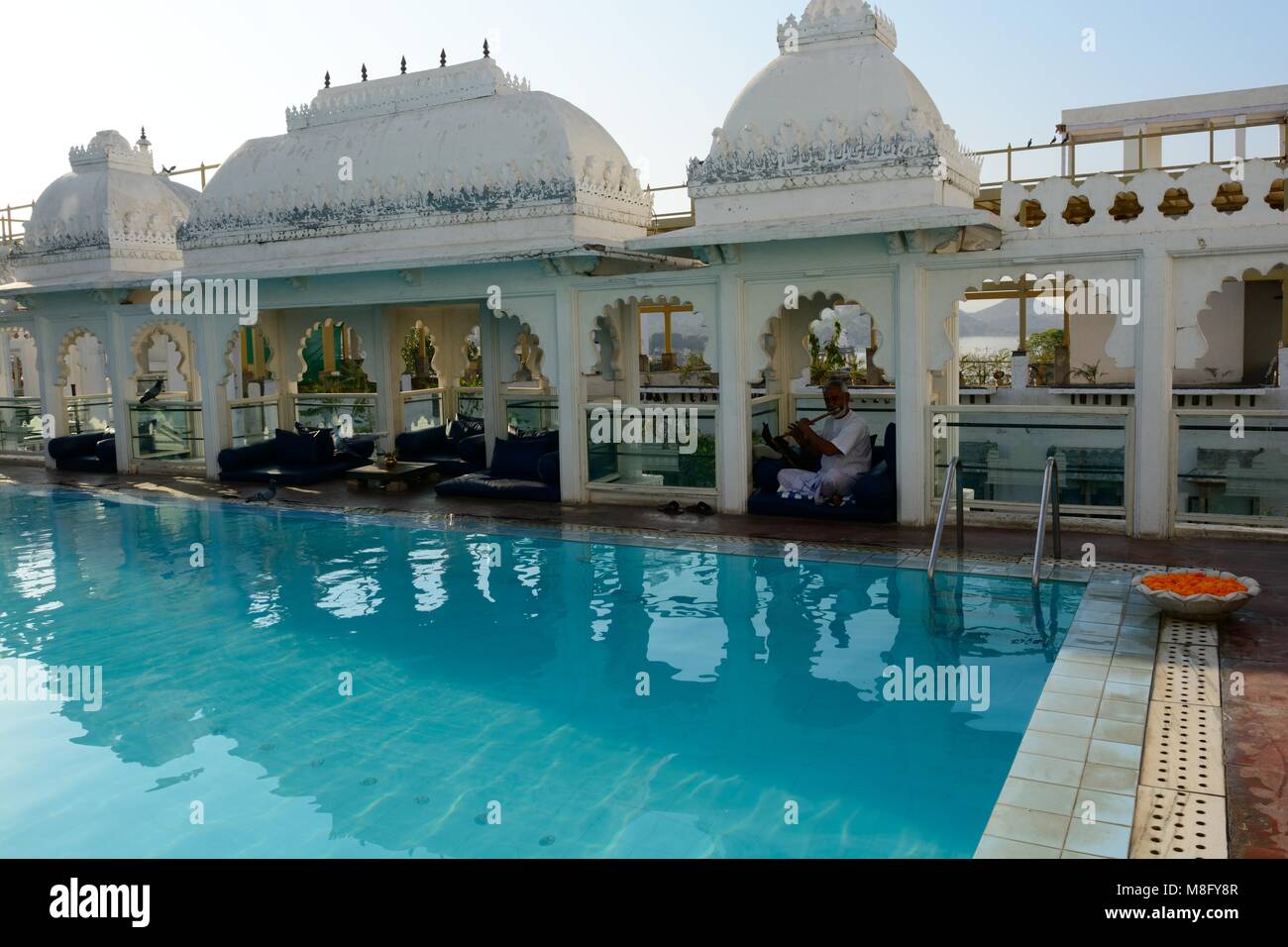 Inder spielen ein Rohr an der ruhigen Swimmingpool auf dem Dach eines Heritage Hotel udaipur Rajashan Indien Stockfoto