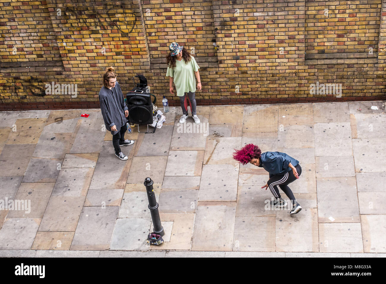 Street Dance improvisierte Leistung durch Hip-Hop-akrobatischen Tänzer außerhalb der alten Truman Brauerei, Ely's Yard, Shoreditch, London, UK Stockfoto